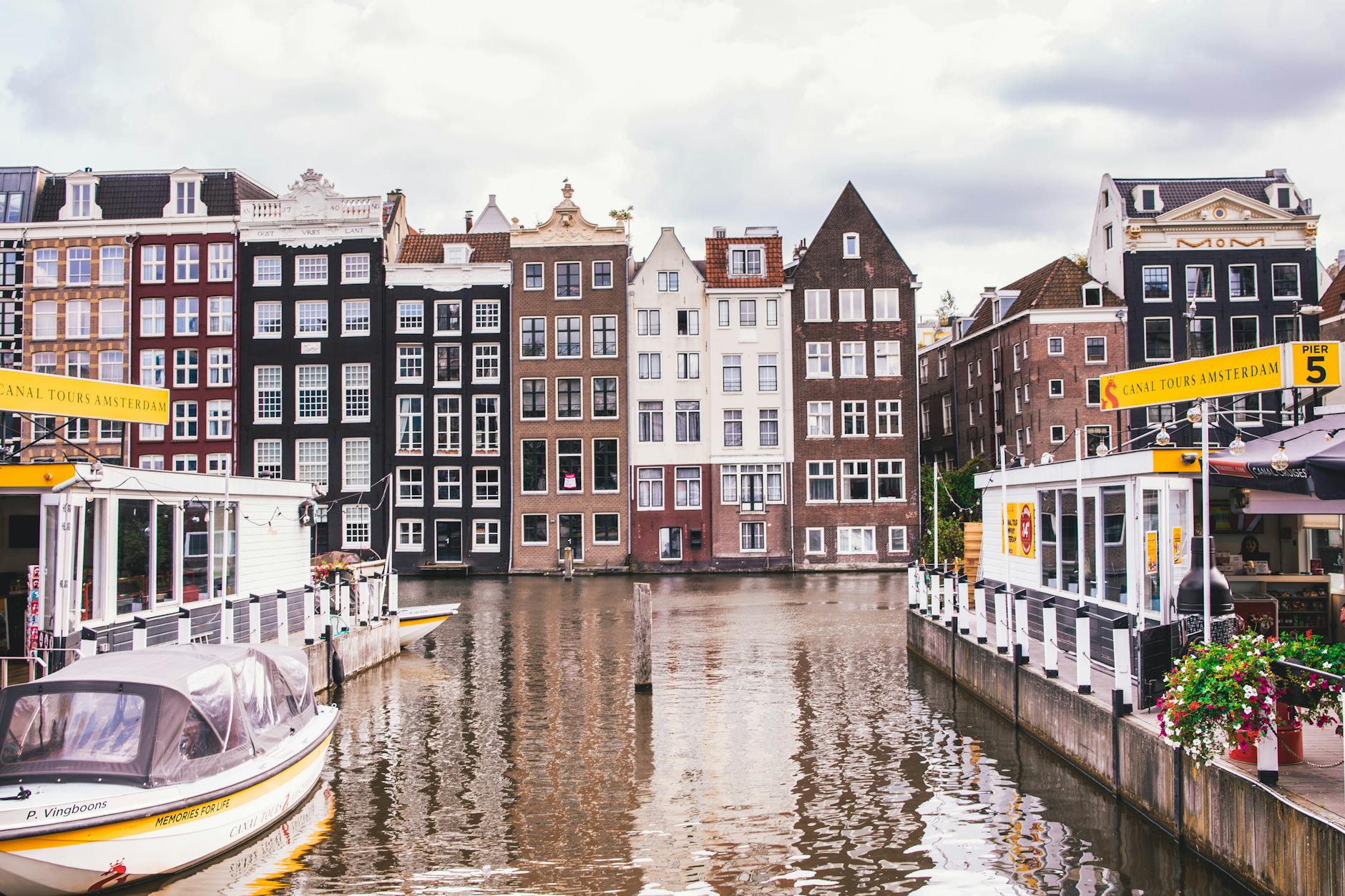 Kanał w Amsterdamie z zabytkowymi kamienicami i kolorowymi odbiciami w wodzie