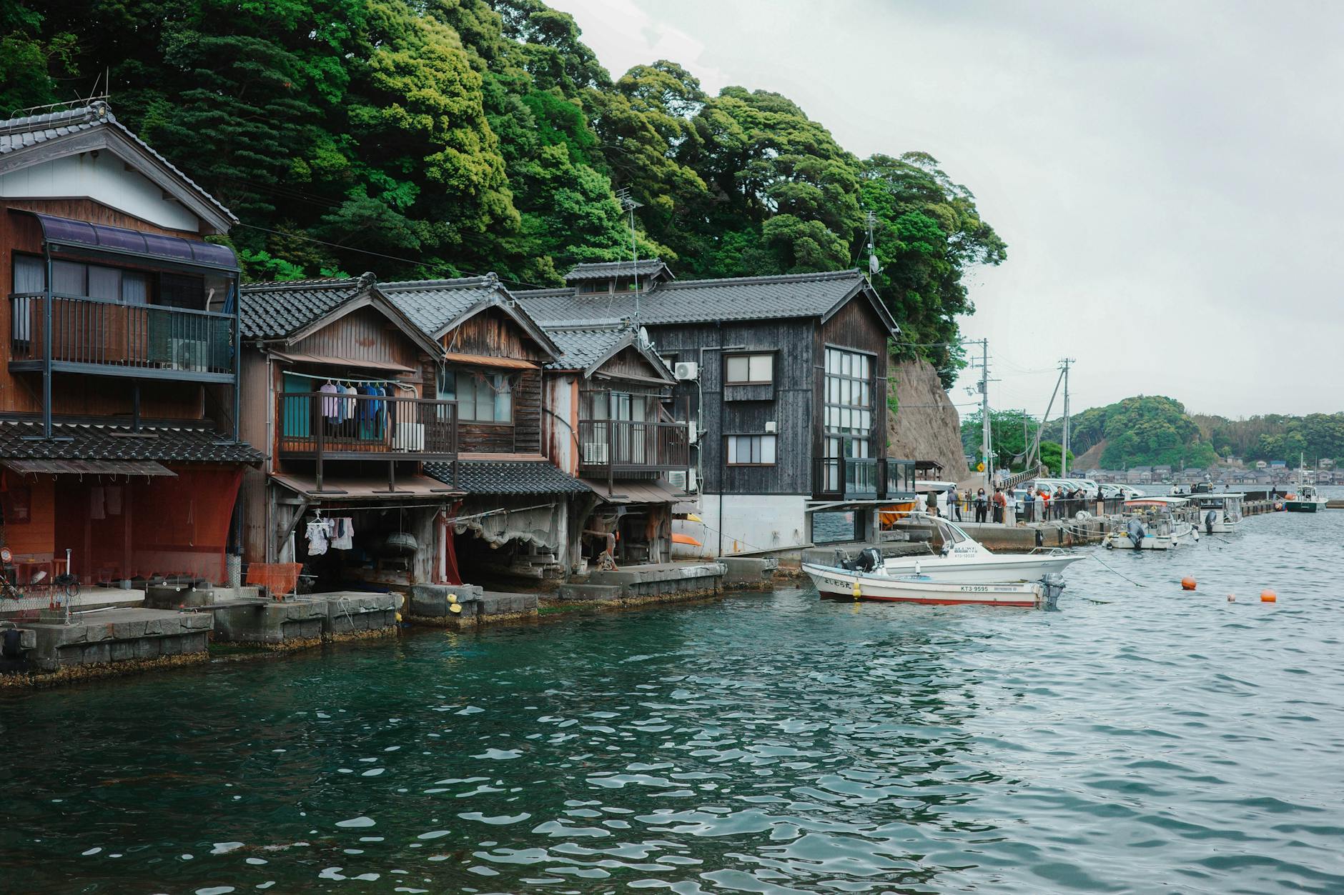 Między morzem a górami: rybackie osady, gorące źródła i świątynie tuż nad wodą Tradycyjne domy łodziarnie nad wodą w rybackiej osadzie Ine w Japonii