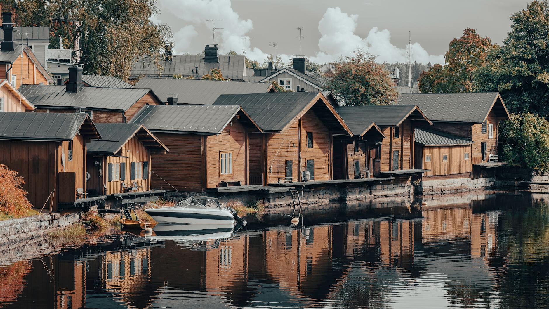 Drewniane domy nad rzeką w Porvoo odbijające się w spokojnej wodzie