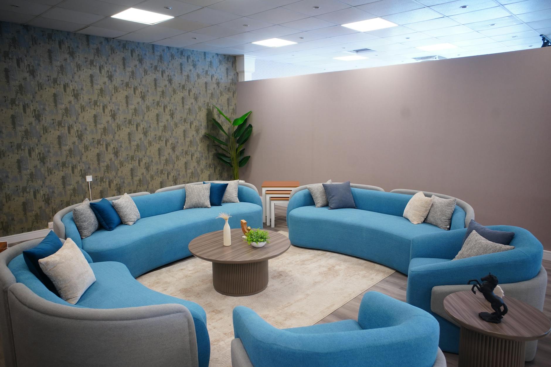 Salon z nowoczesnymi niebieskimi sofami i przytulnymi dodatkami