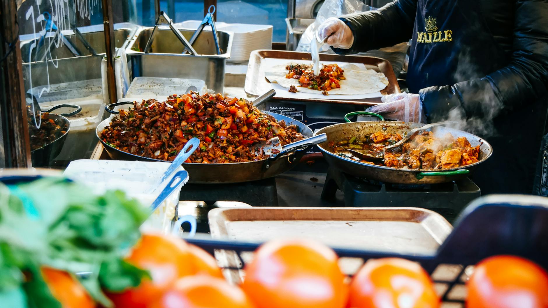 Szef kuchni przygotowuje street food na zatłoczonym londyńskim markecie