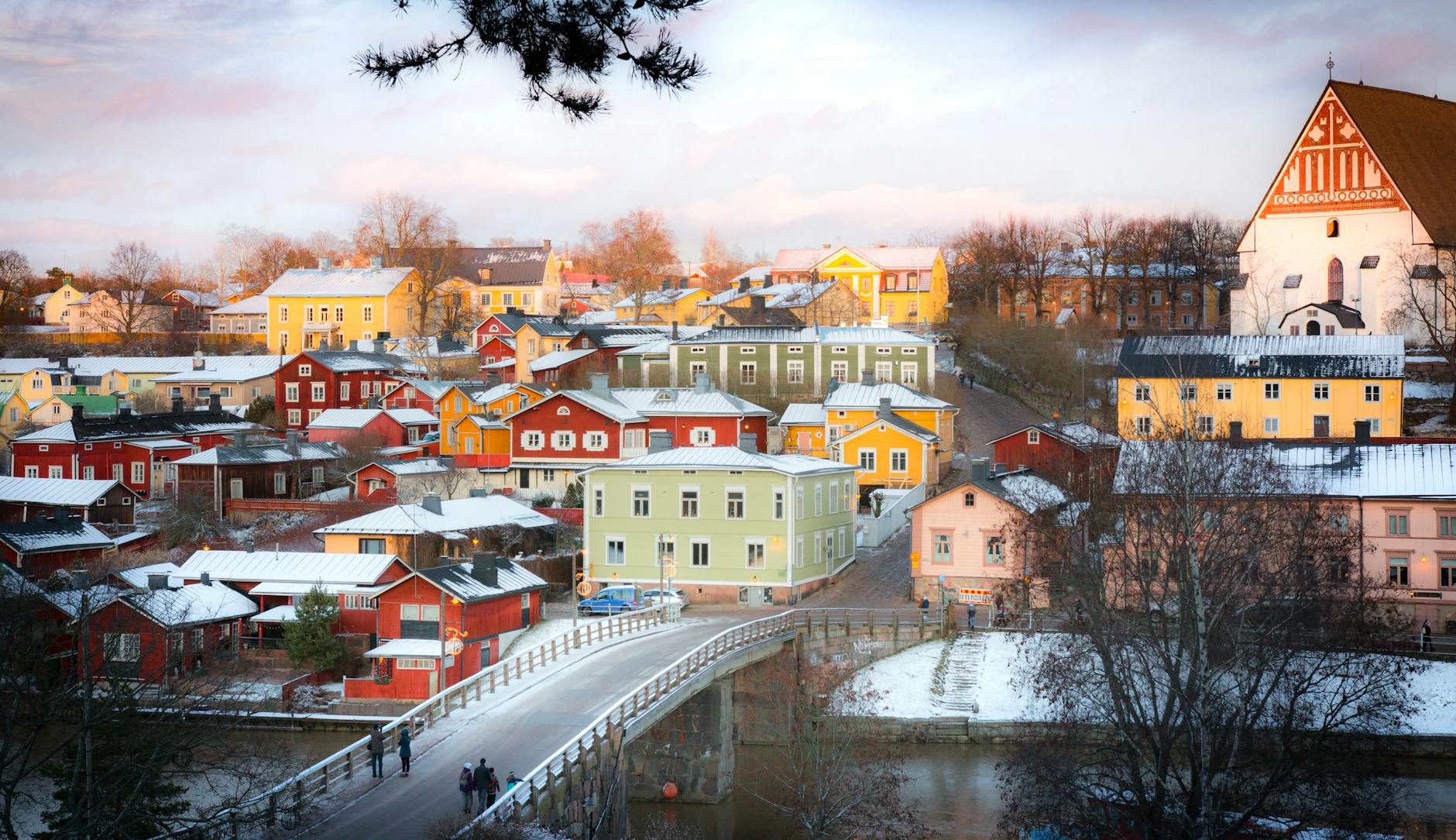 Zimowy widok kolorowych drewnianych domów w Porvoo znad mostu